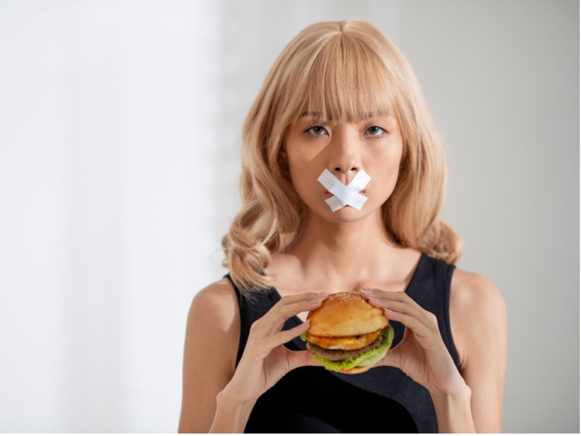 Eine Frau hält einen Burger in der Hand