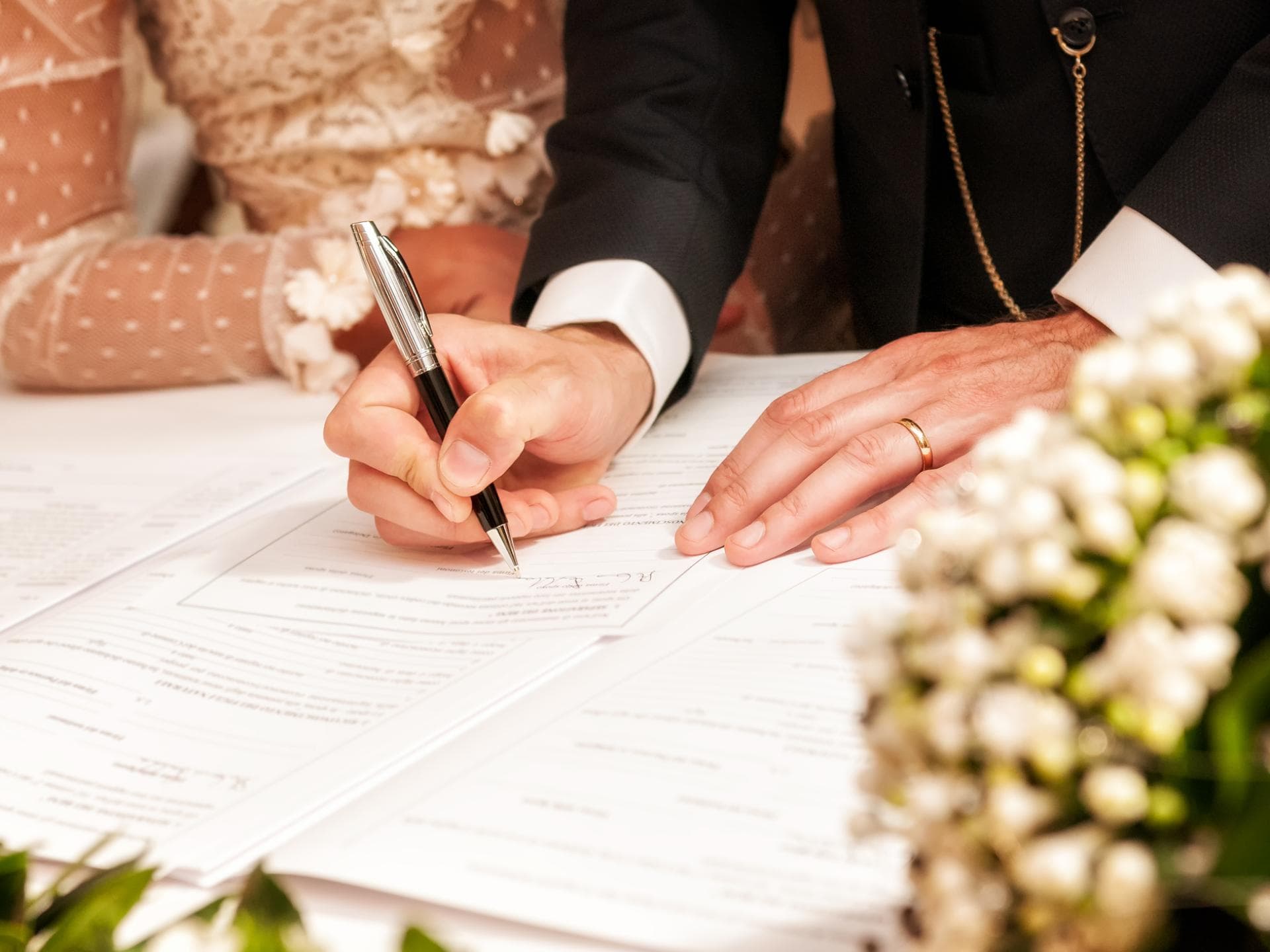 Brautpaar unterschreibt bei standesamtlicher Hochzeit 