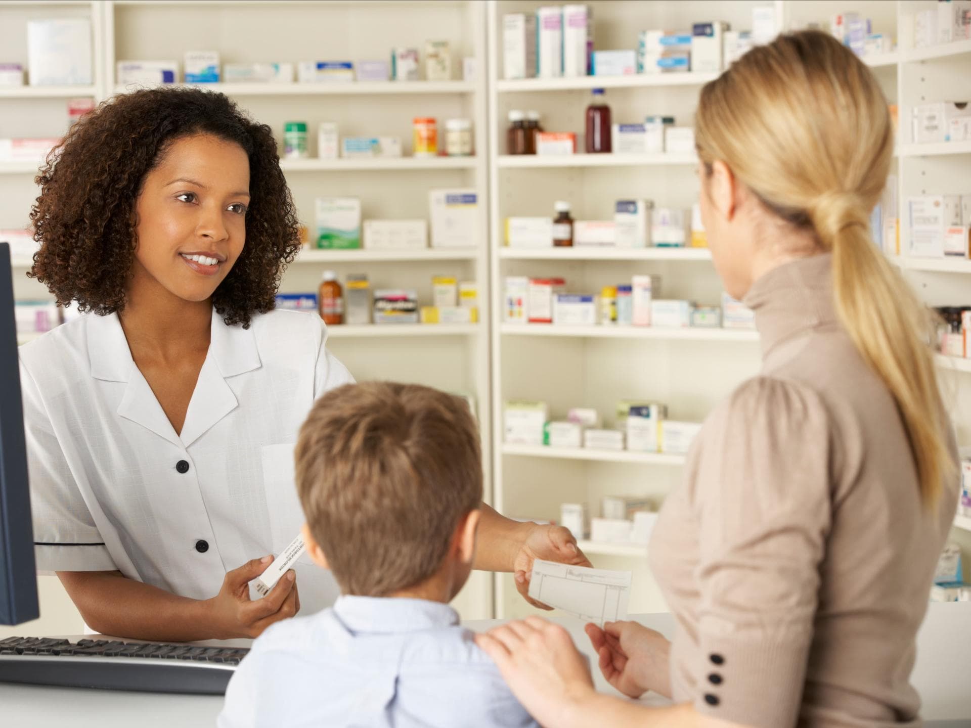 Apothekerin berät Frau mit Kind