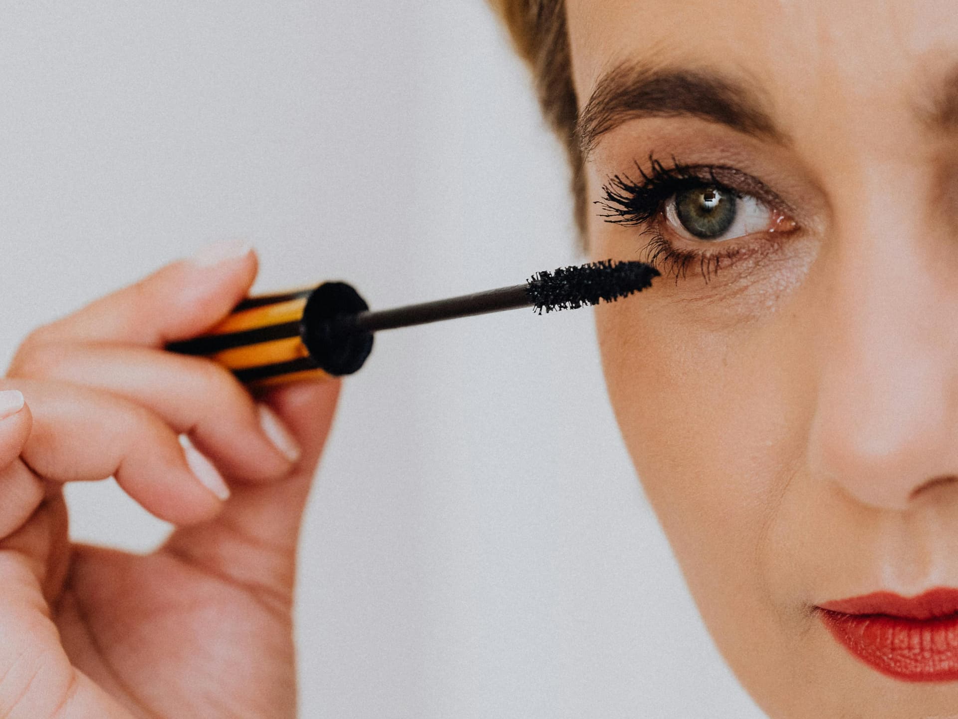 Frau trägt wasserfeste Mascara auf ihre Wimpern auf
