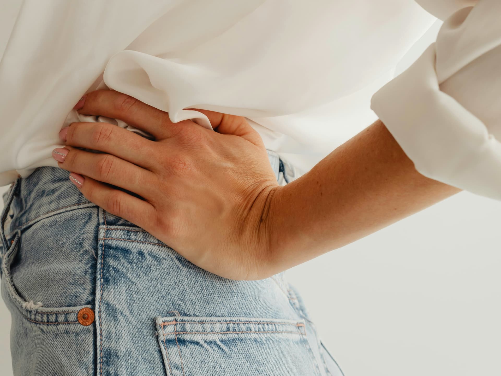 Frau trägt eine zu eng gewordene Jeans