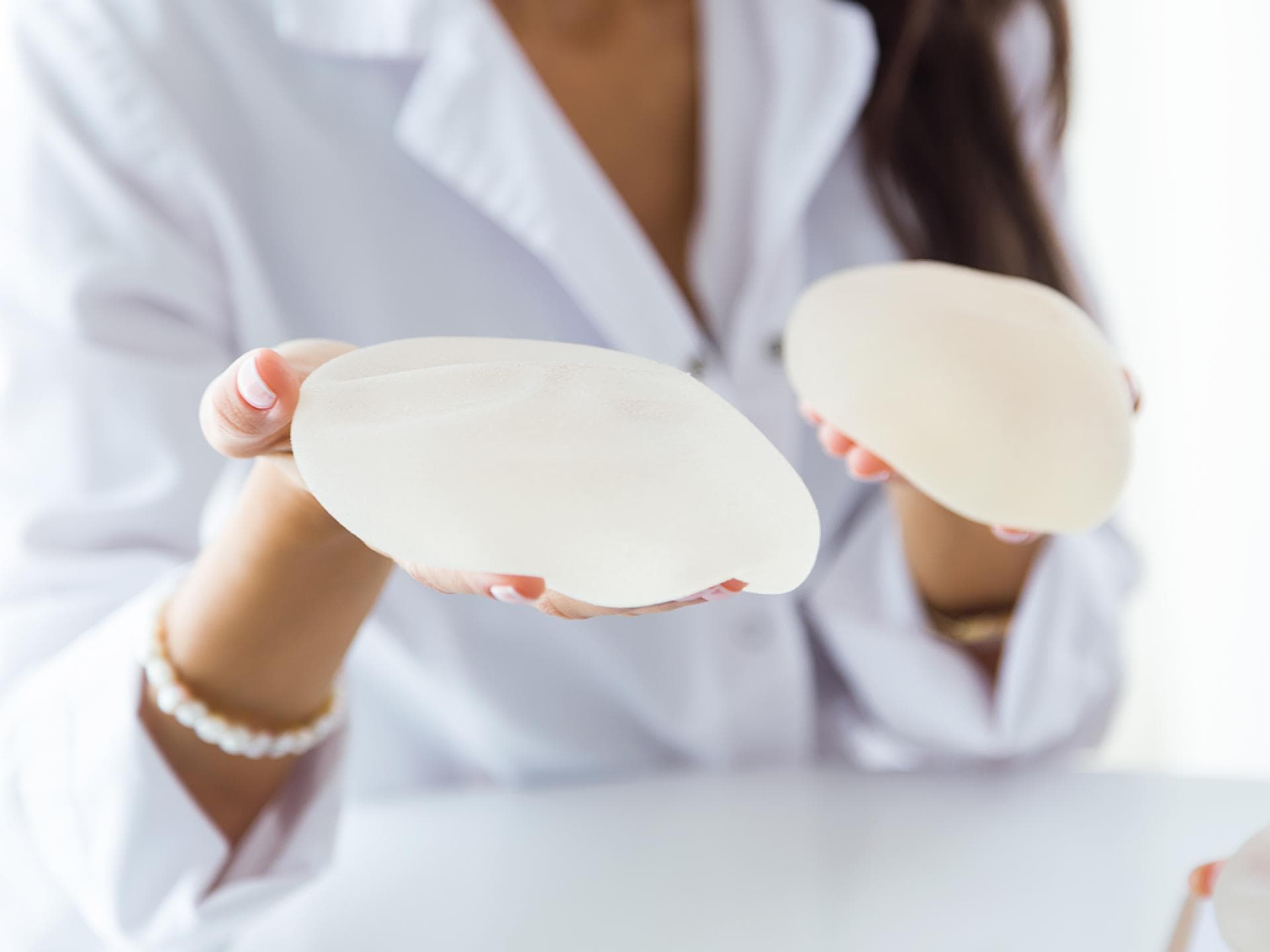 Eine Frau hält Implantate in der Hand