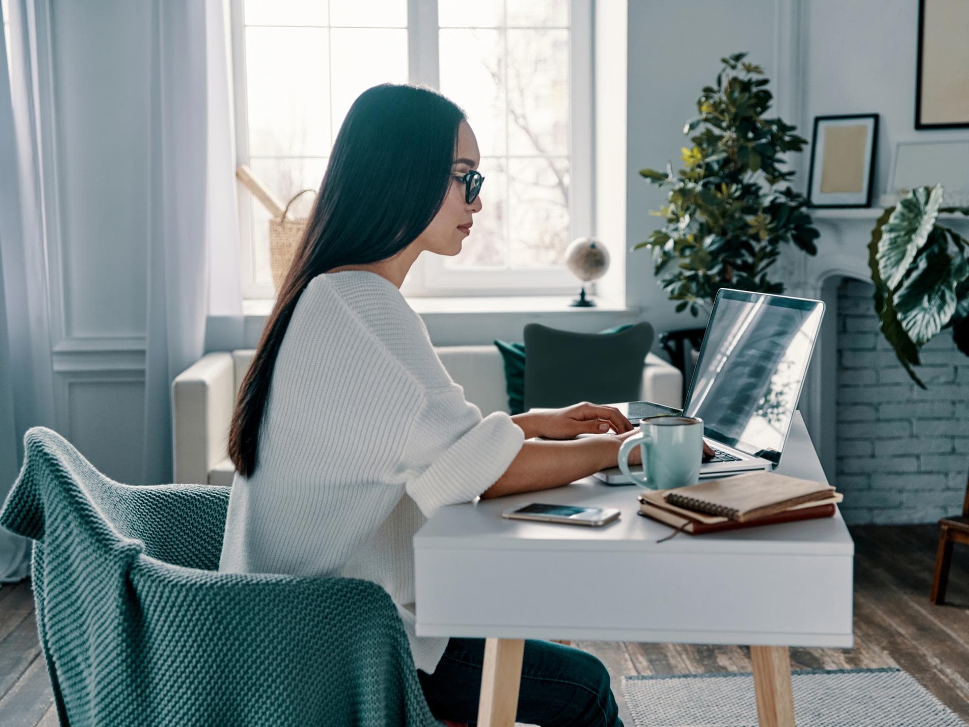 Eine Frau sitzt am Laptop und arbeitet