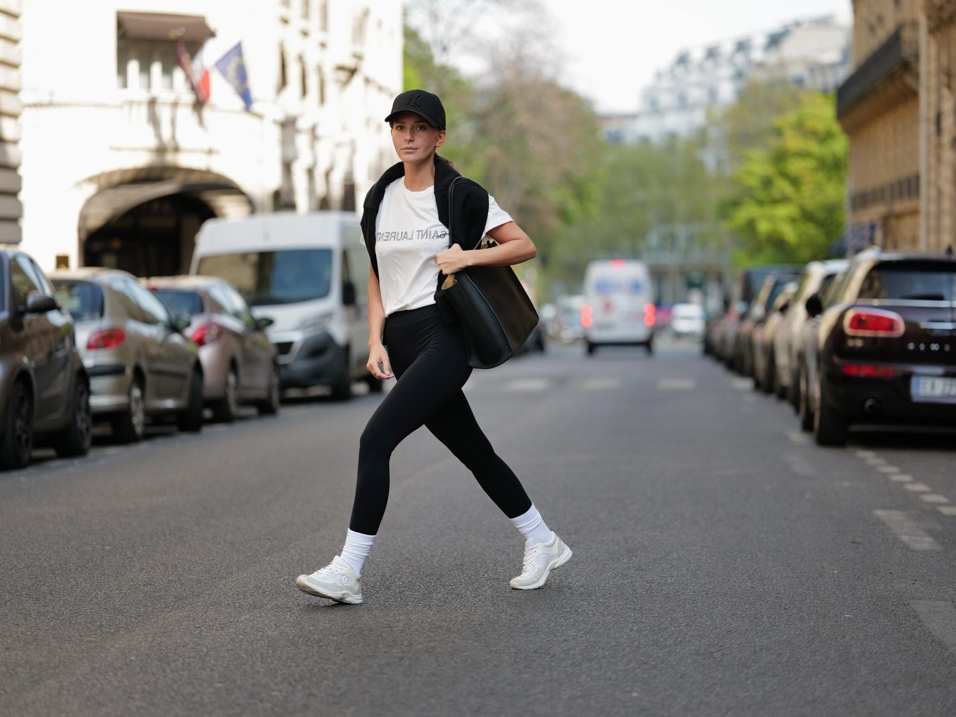 Diane Batoukina trägt schwarze Sport-Leggings weißes T-Shirt schwarze Cap und schwarze Tasche