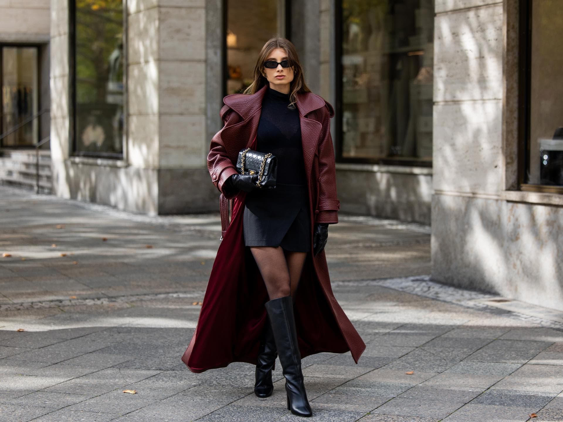Frau trägt einen langen Mantel über einem Rock und Pullover