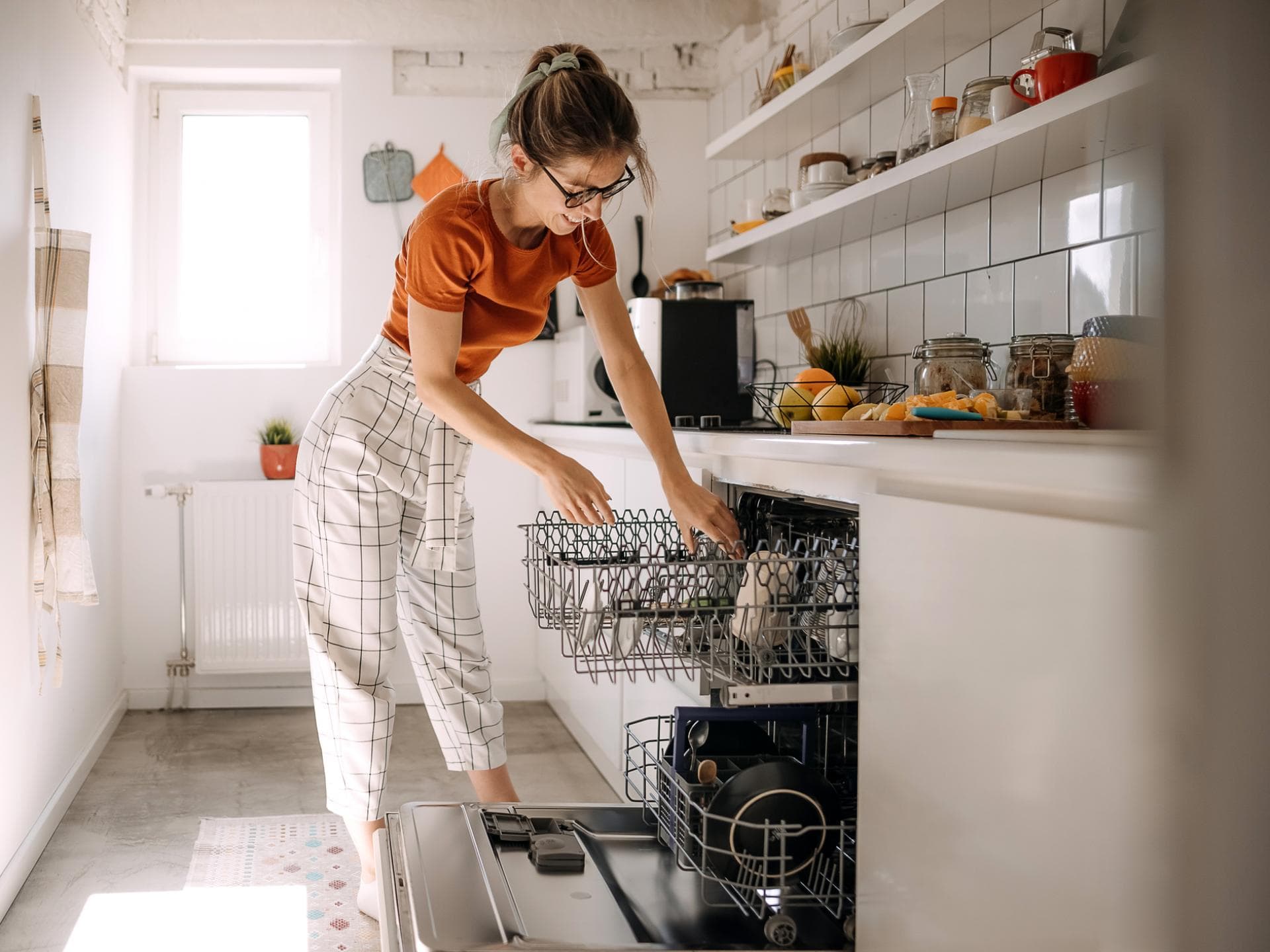 Eine Frau räumt die Spülmaschine ein