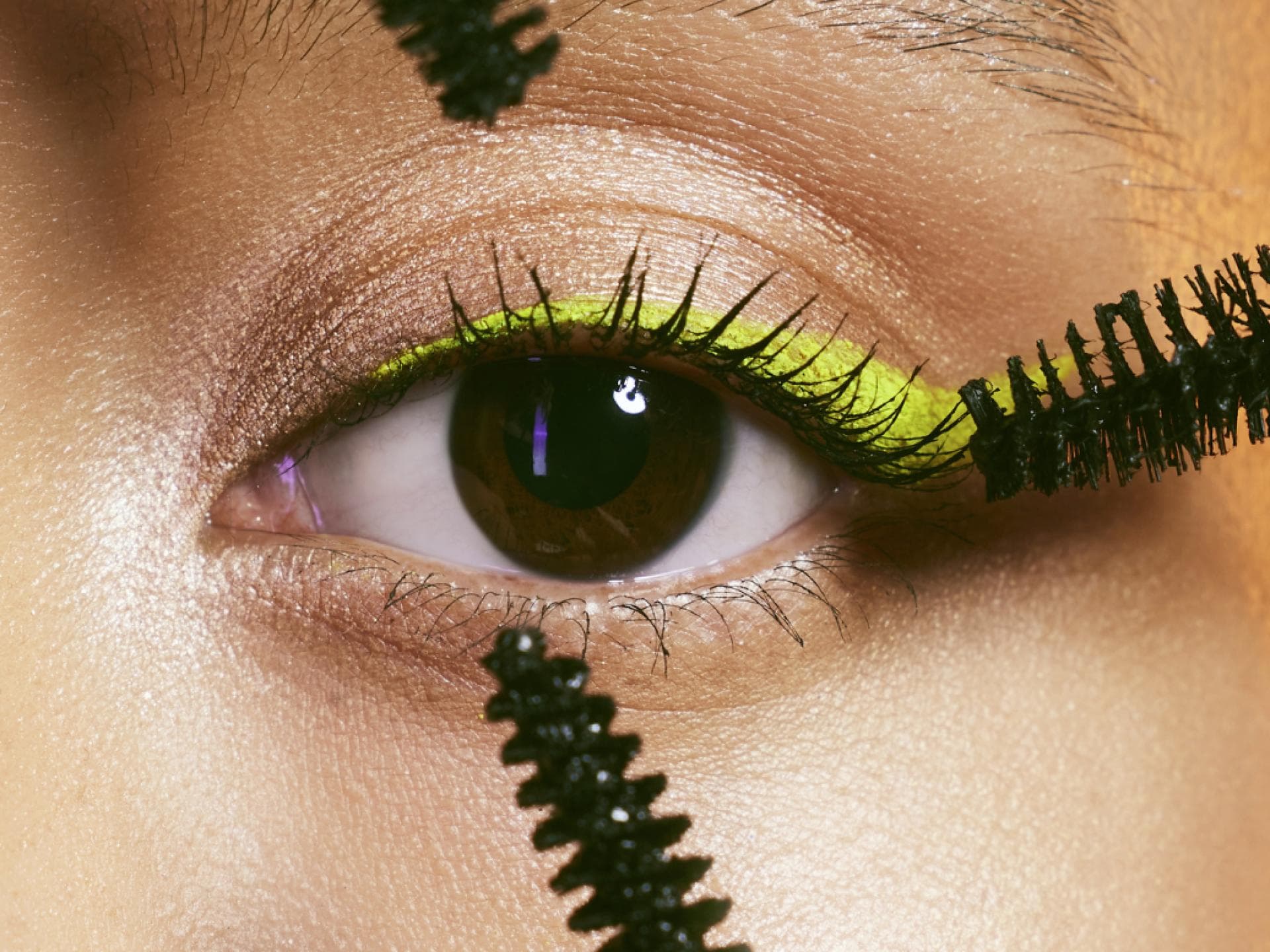 Braunes Auge mit neon-lidstrich und mehreren wimpern-bürsten