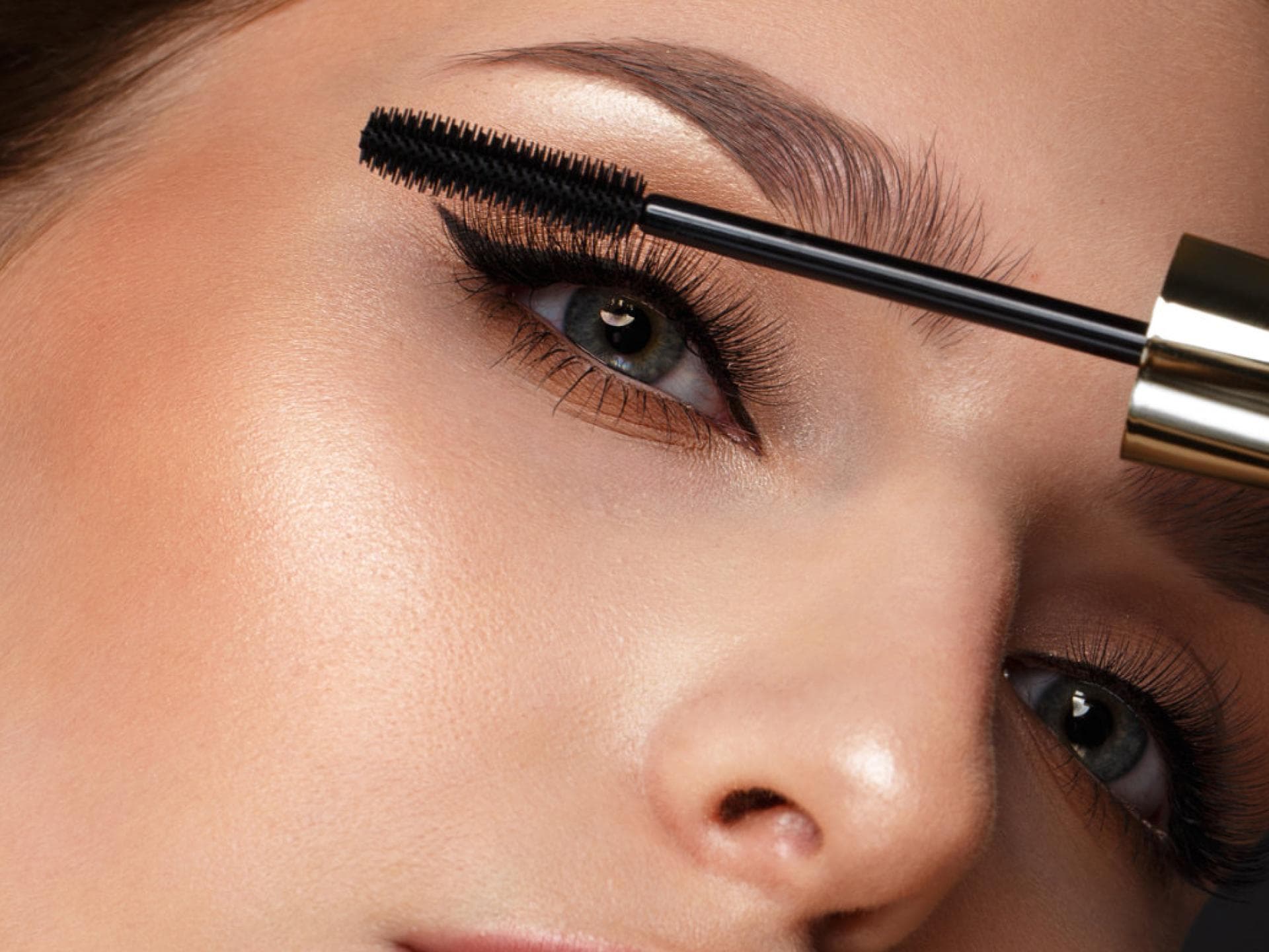 Schöne Frau trägt Mascara auf