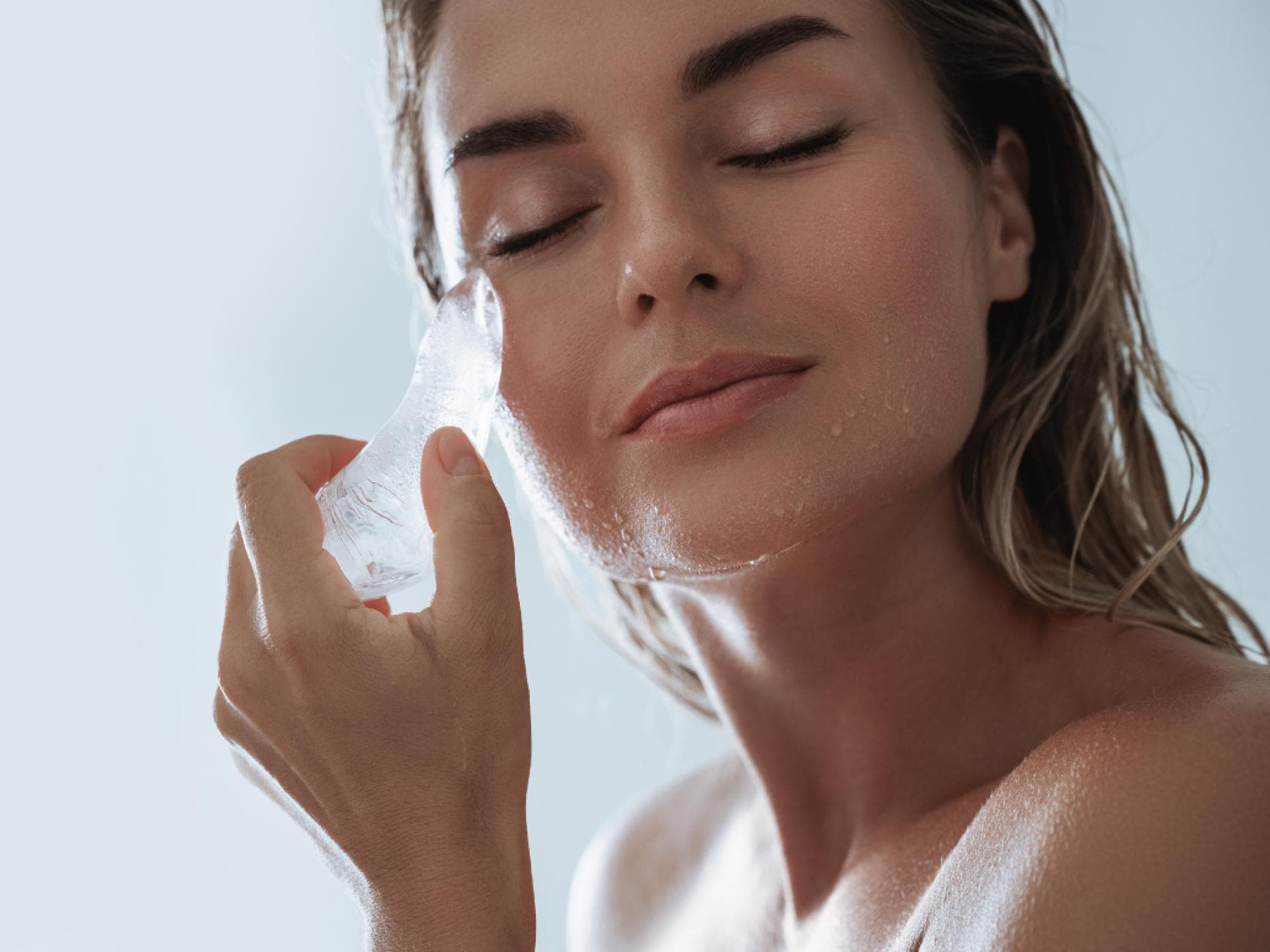 schöne Frau mit Eis am Gesicht