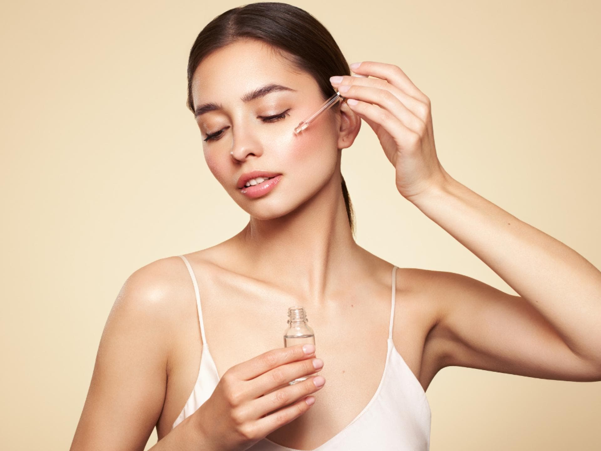 Frau vor allem Hintergrund trägt Serum auf