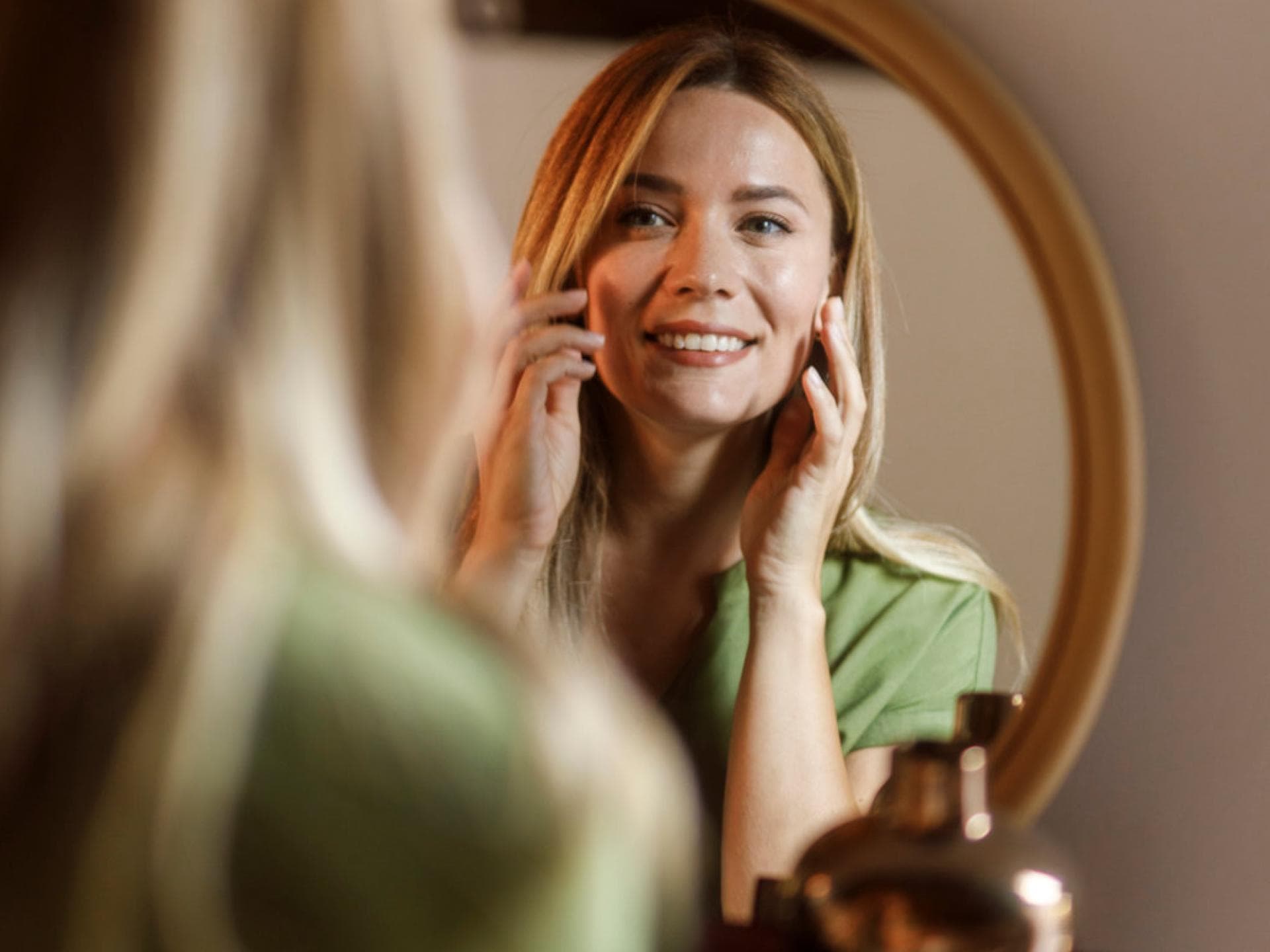 Frau strahlt sich im Spiegel an