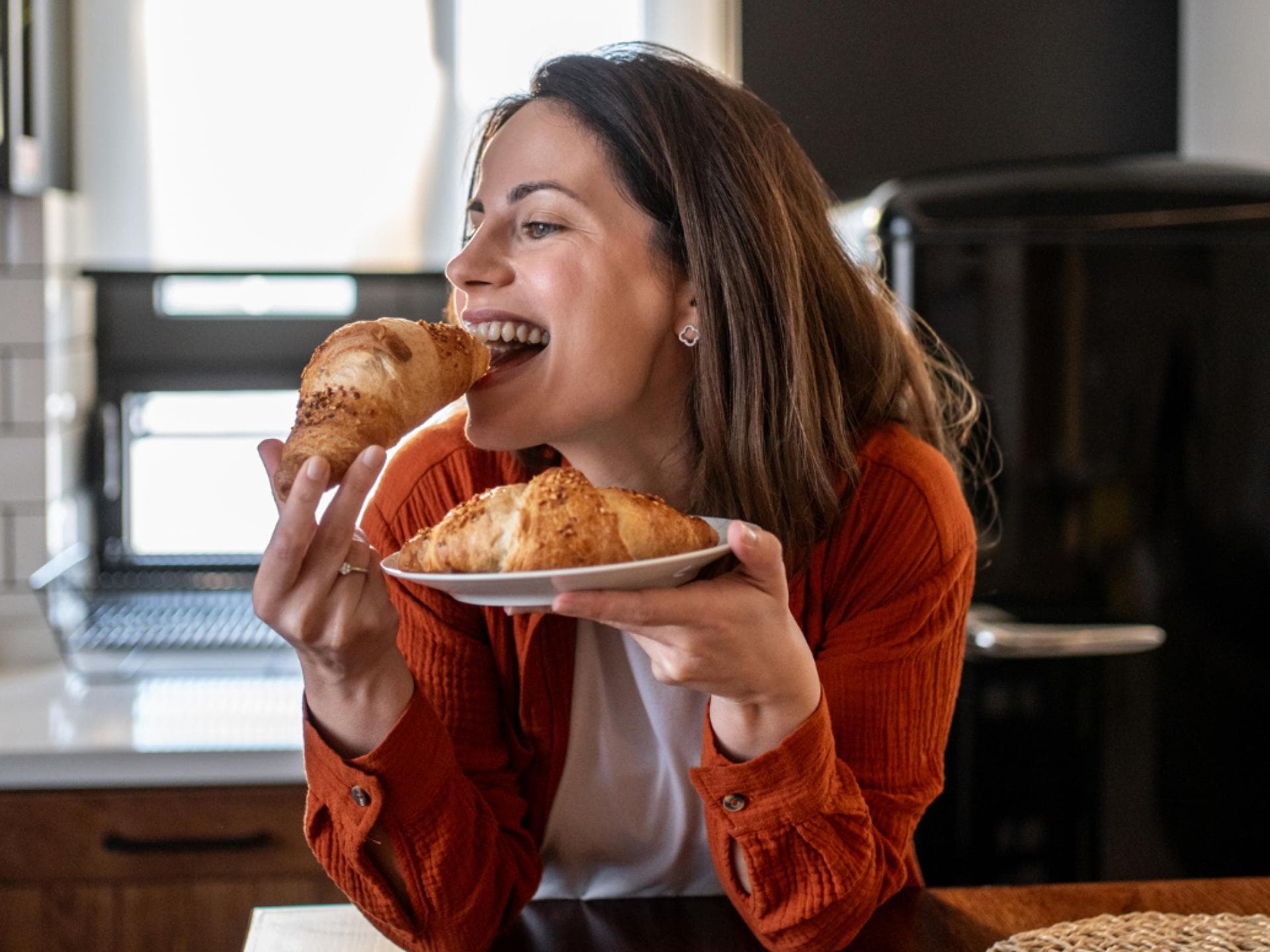 Frau beisst in Croissant