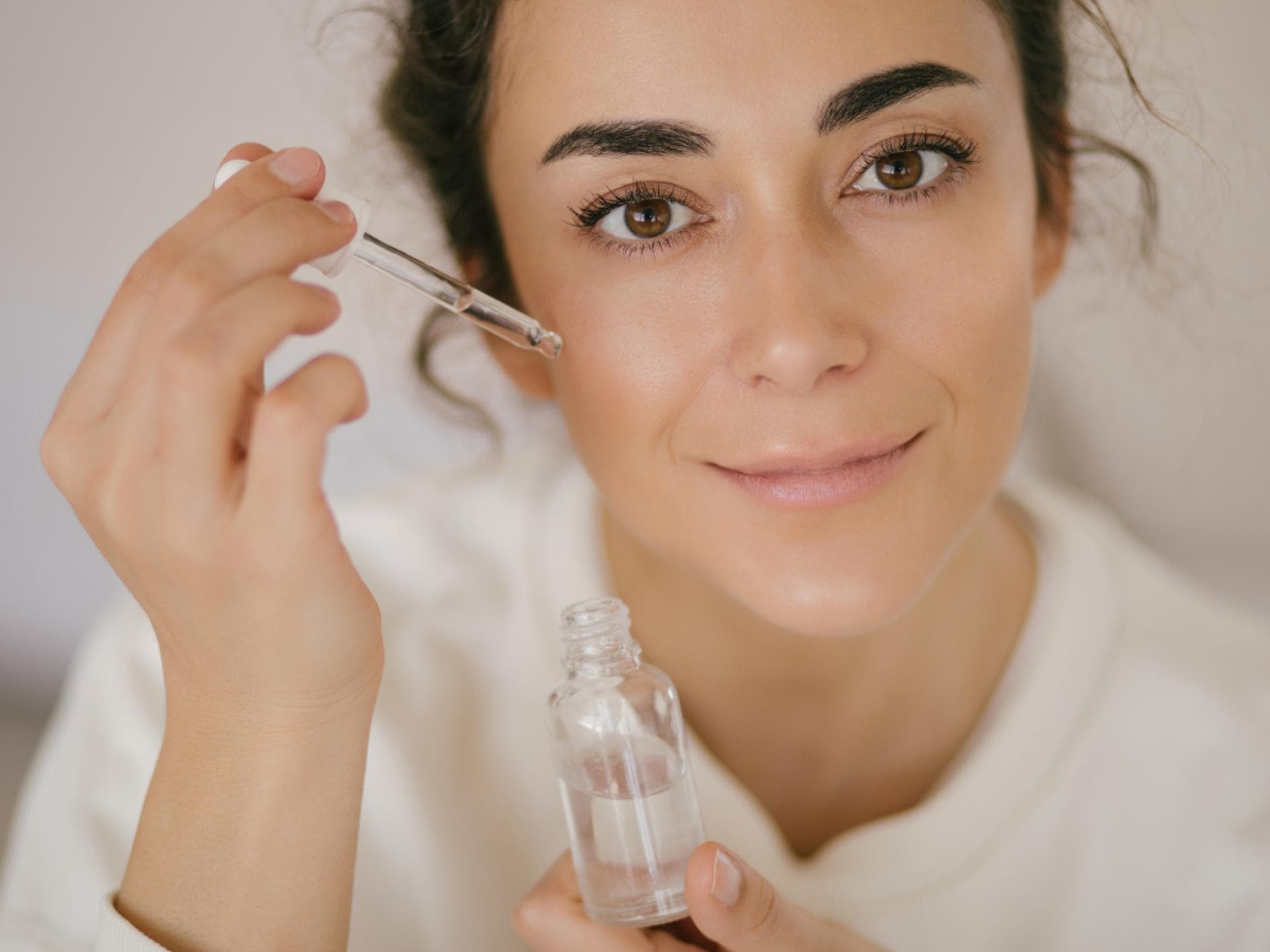 Brünette trägt Hyaluron auf die Haut auf