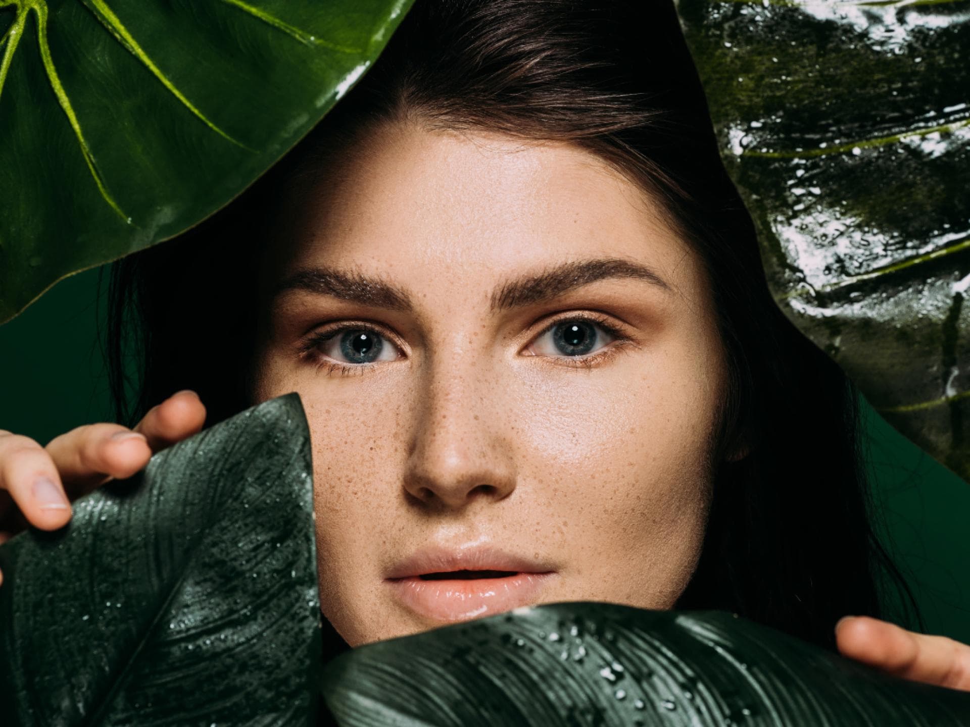 Frau hinter grünen Blättern
