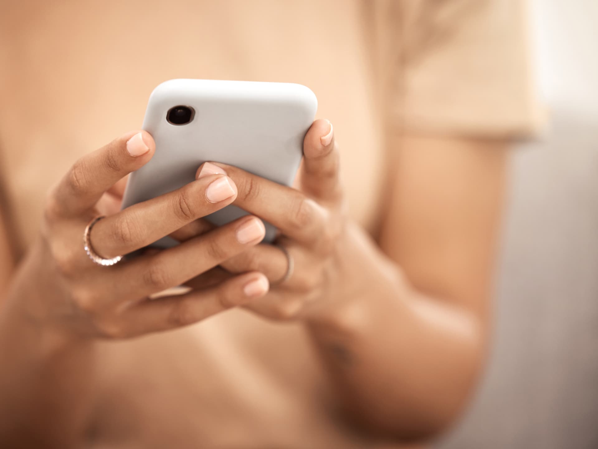 Nicht nur Stars, auch normale Menschen werden immer öfter Opfer von Deepfakes Frau schaut auf ihr Smartphone