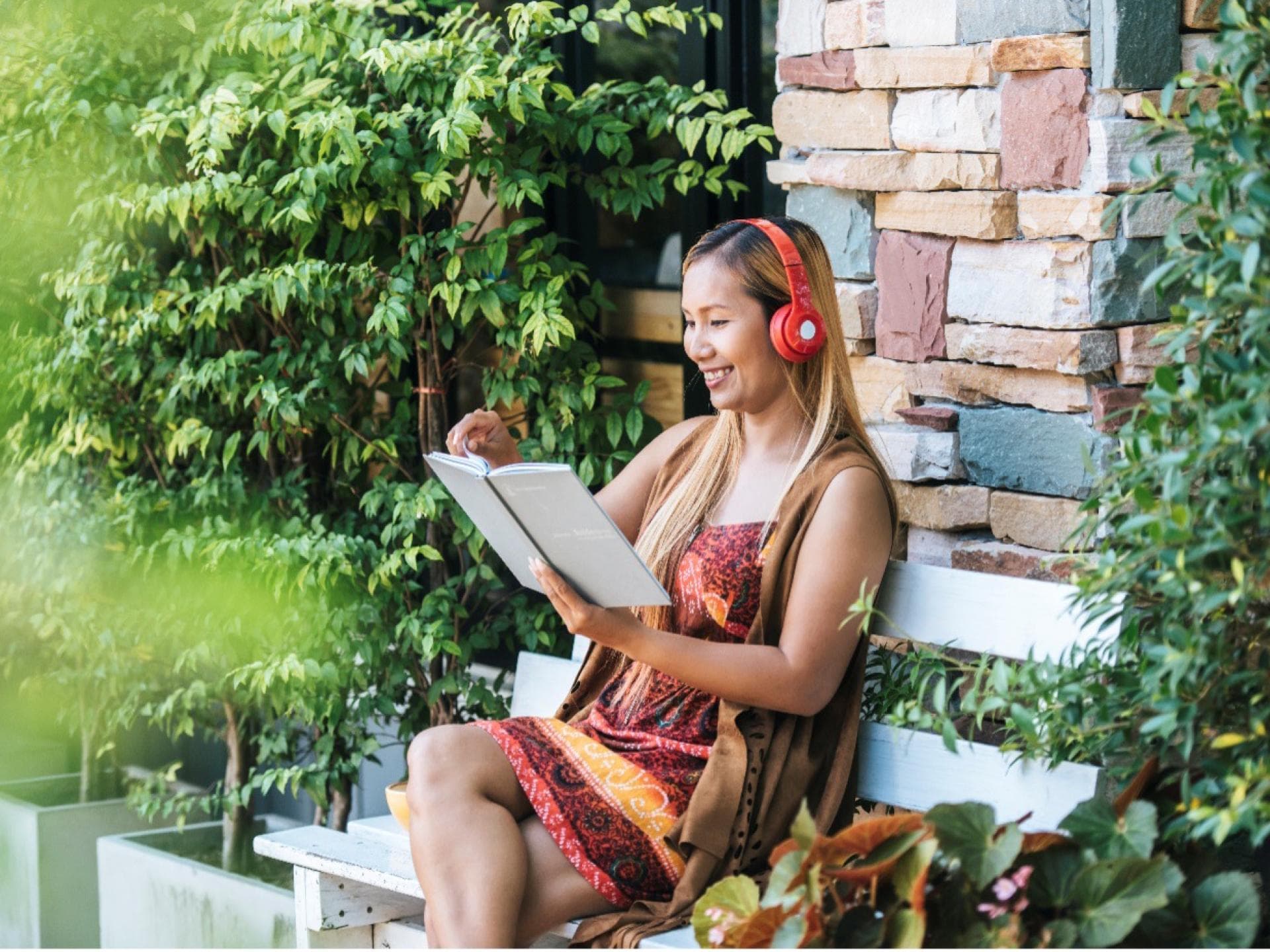 Eine Frau liest ein Buch im Garten