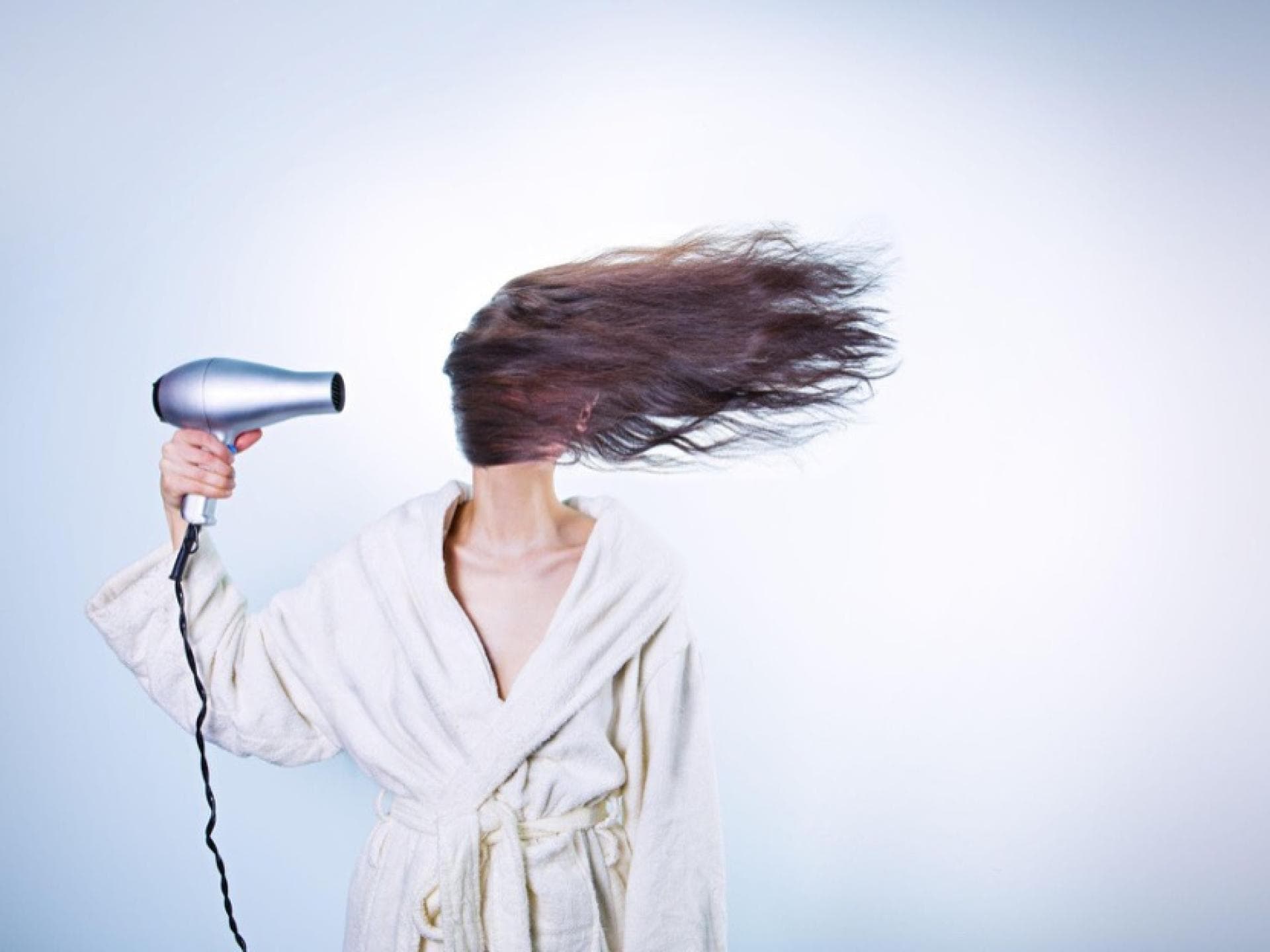 Eine Frau föhnt ihre Haare