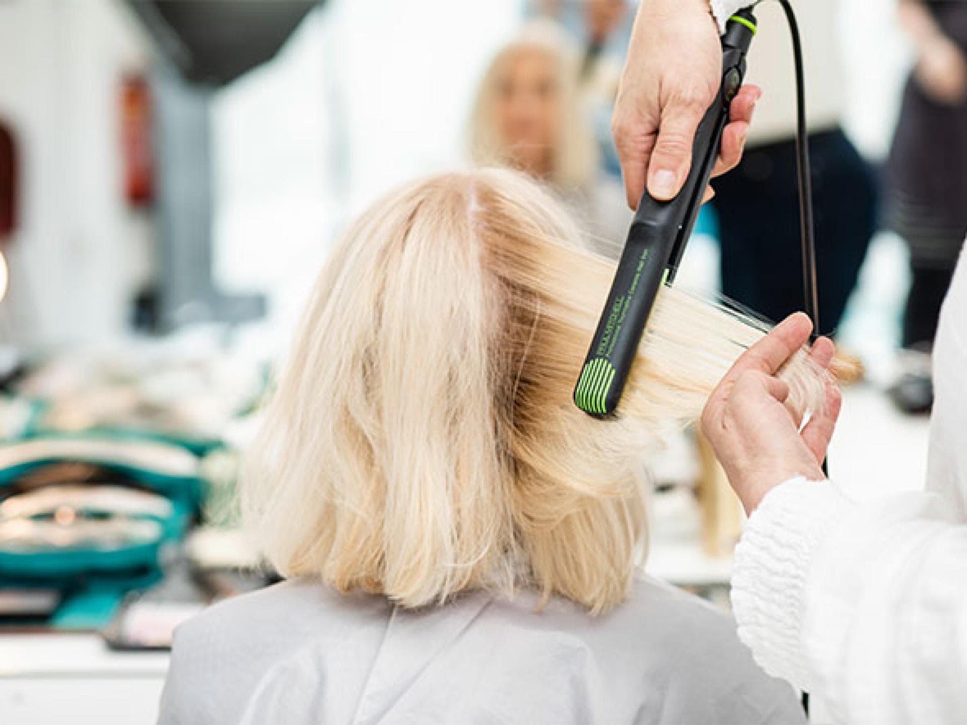 Helga werden die Haare geglättet