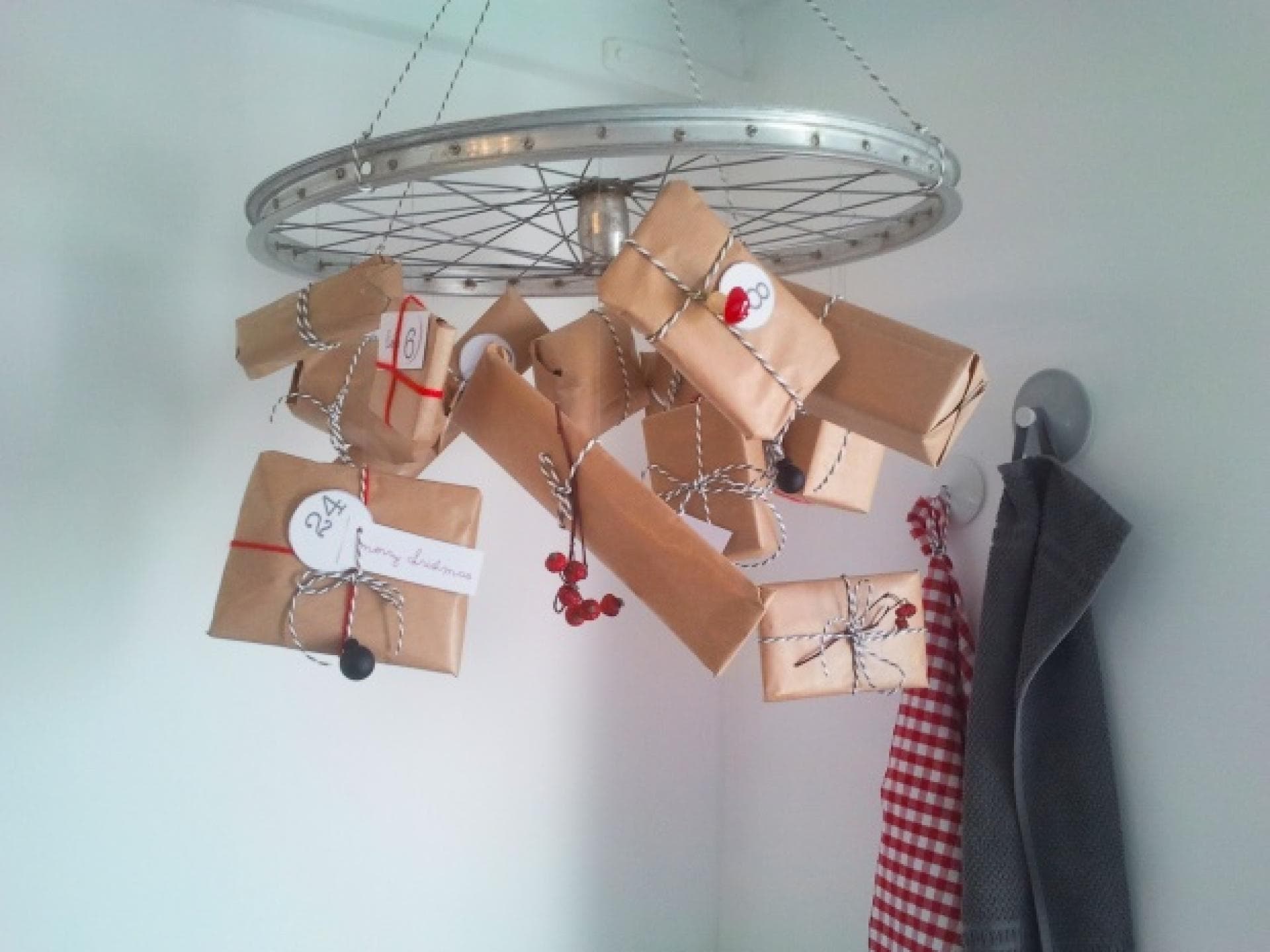 Selbstgemachter Adventskalender mit Geschenken an einem Rad