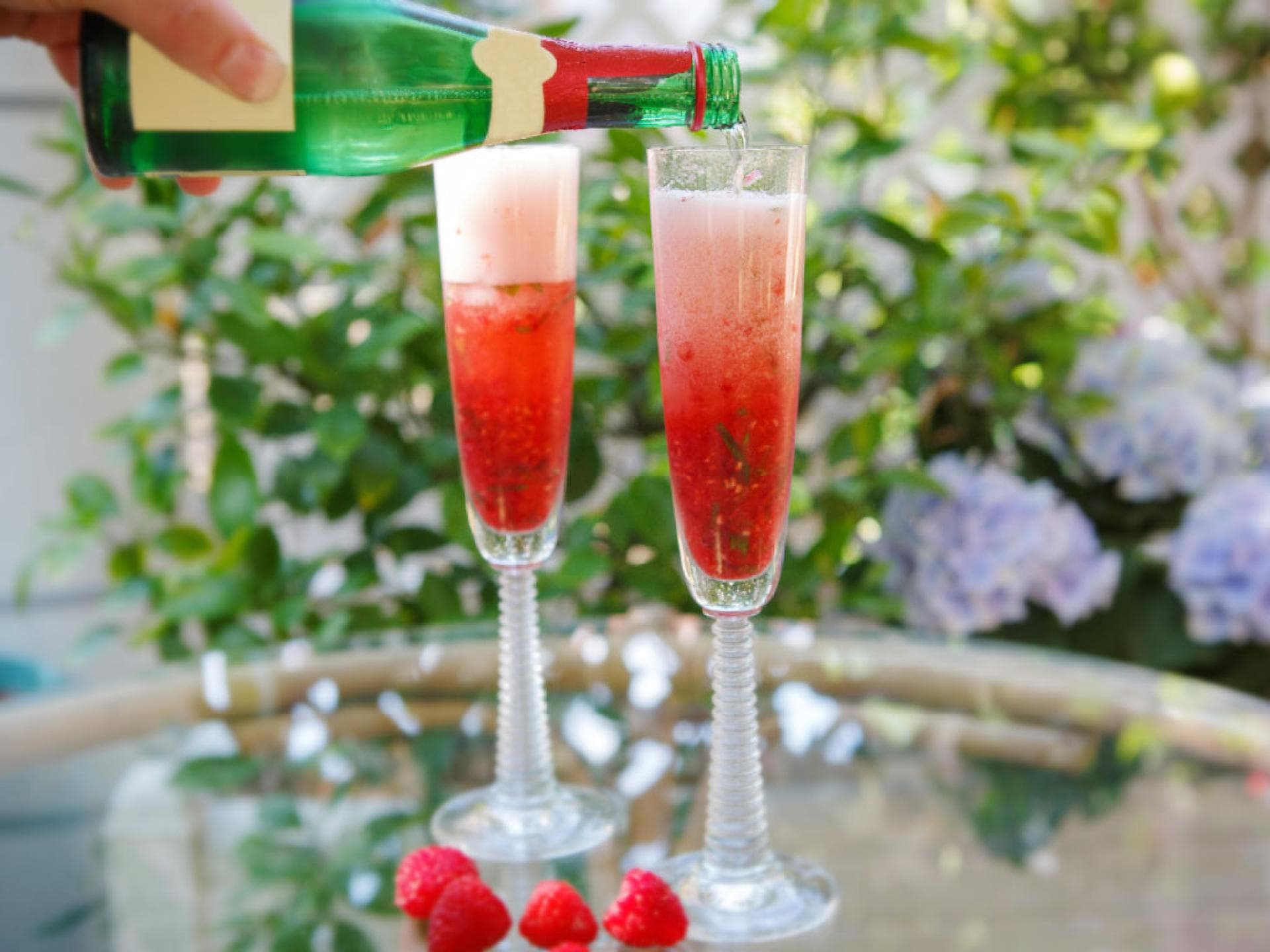 Sekt wird auf Erdbeeren eingeschenkt