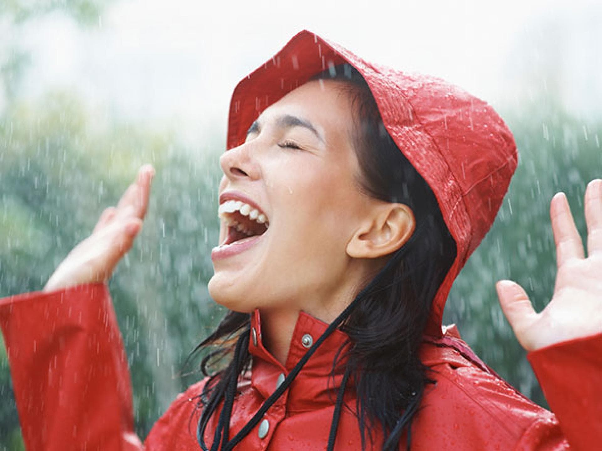 Optimismus für ein glückliches Leben - Frau lacht im Regen