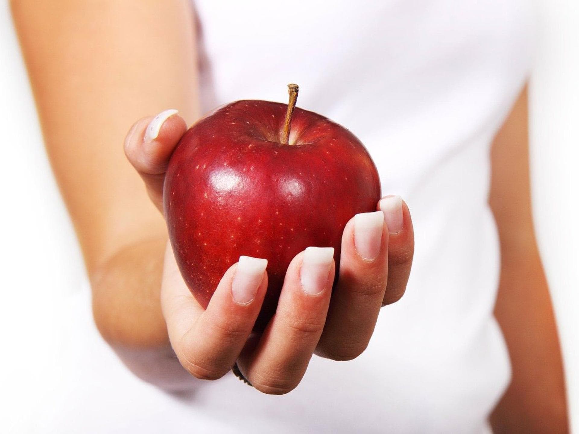Frau mit Apfel: Gesund und fit bleiben im Homeoffice Frau mit Apfel: Gesund und fit bleiben im Homeoffice