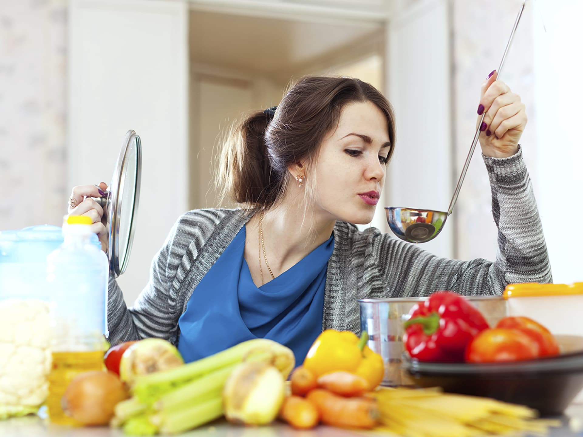 Frau kocht kalorienarm Frau kocht und probiert von einer Kelle - So kochen Sie kalorienarm und gesund