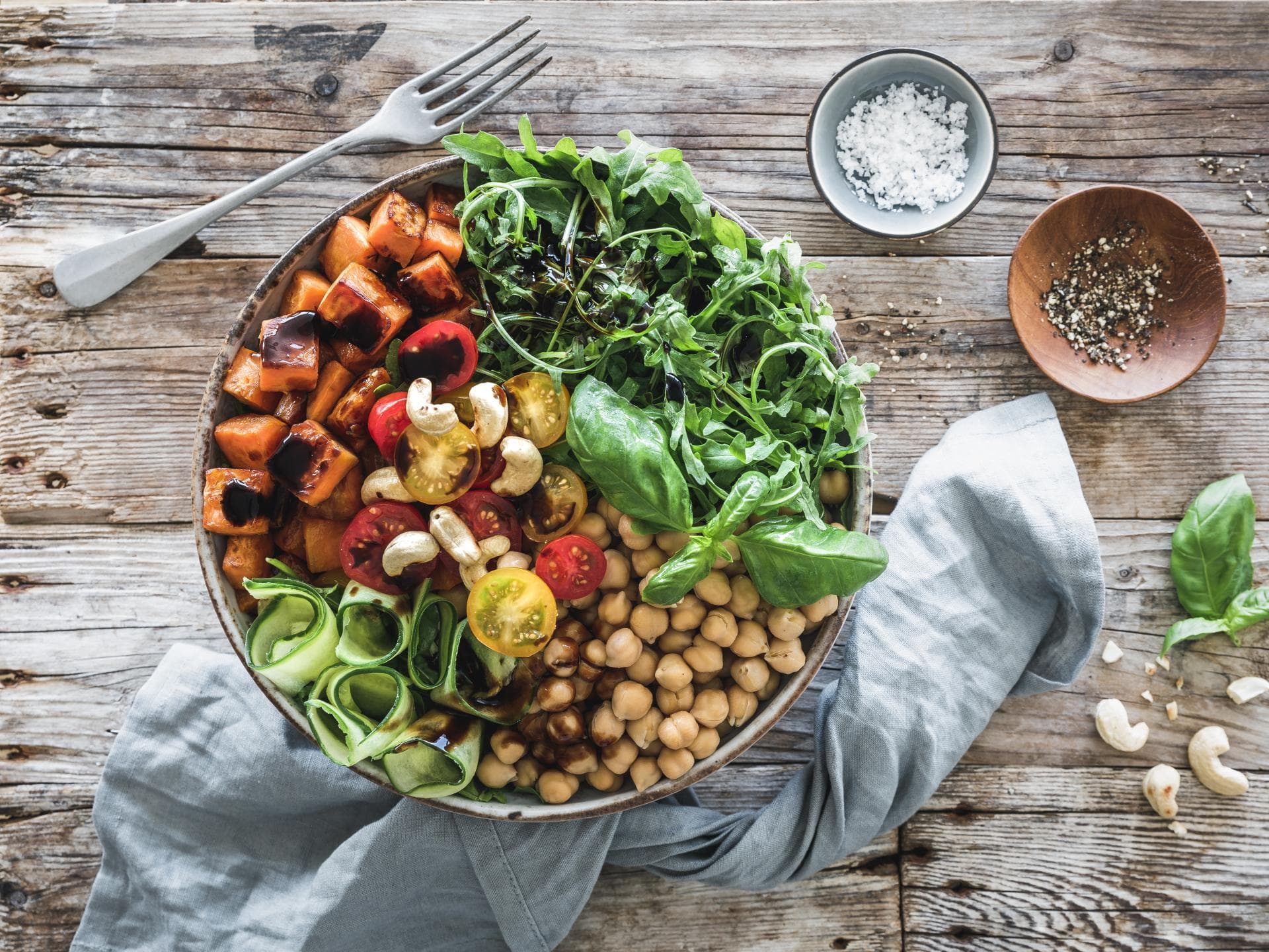 Salat-Bowl mit gerösteten Süßkartoffeln, Rucola und bunten Tomaten Salat-Bowl mit gerösteten Süßkartoffeln, Rucola und bunten Tomaten
