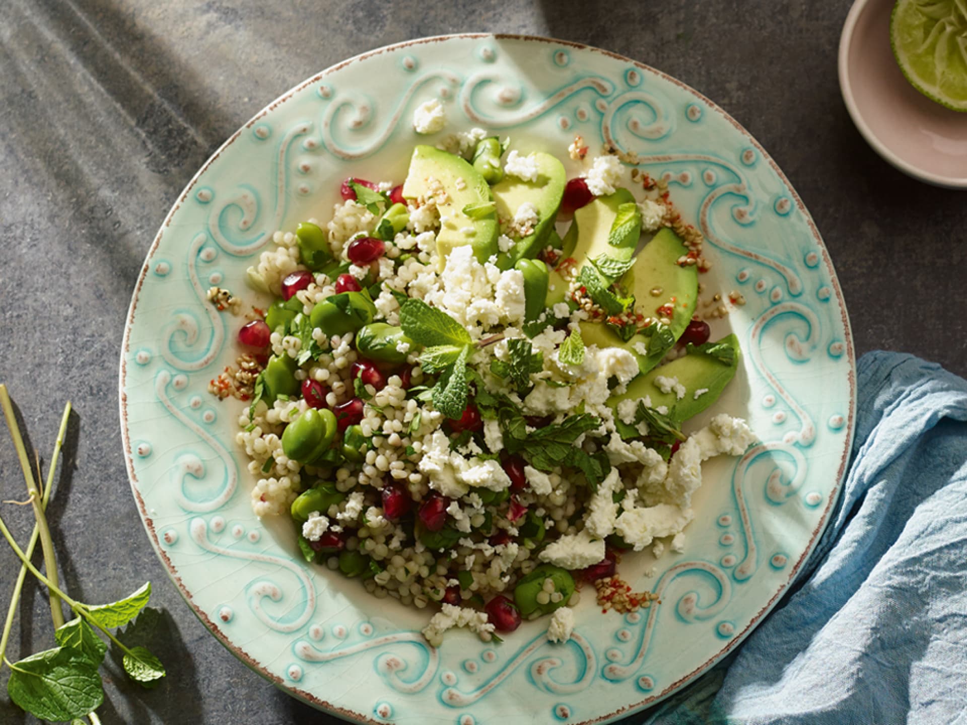 Perlgraupensalat mit Granatapfel und Feta perlgraupensalat mit Granatapfel und Feta auf einem Teller, angerichtet mit Avocado