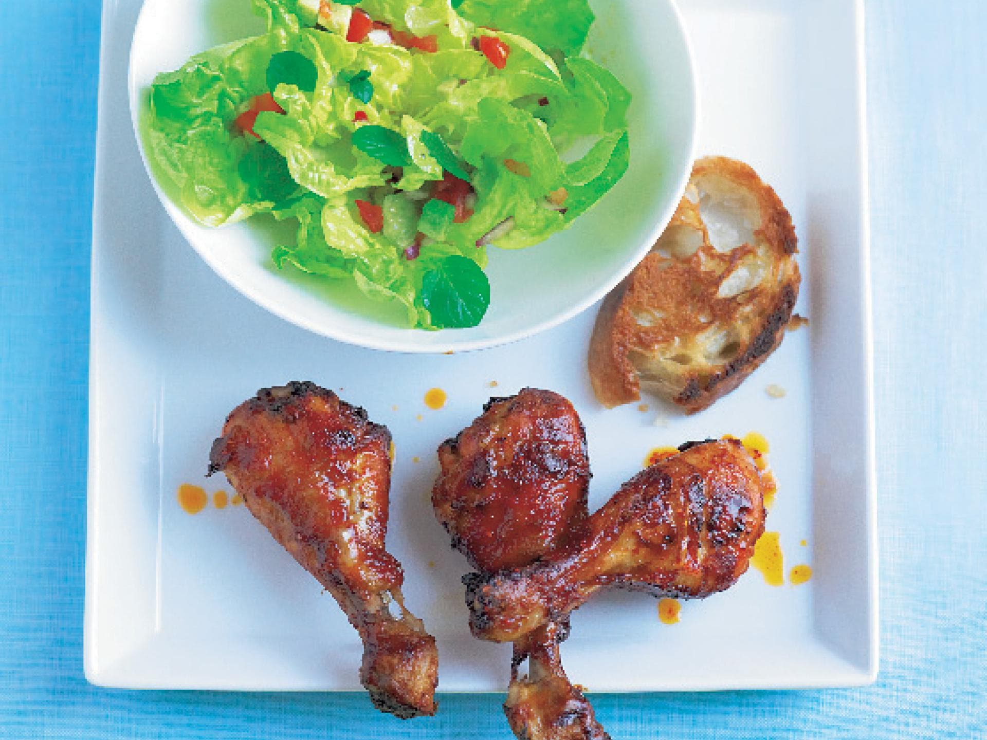 Scharfe Hähnchenkeulen mit frischem Salat - Das Rezept finden Sie bei uns