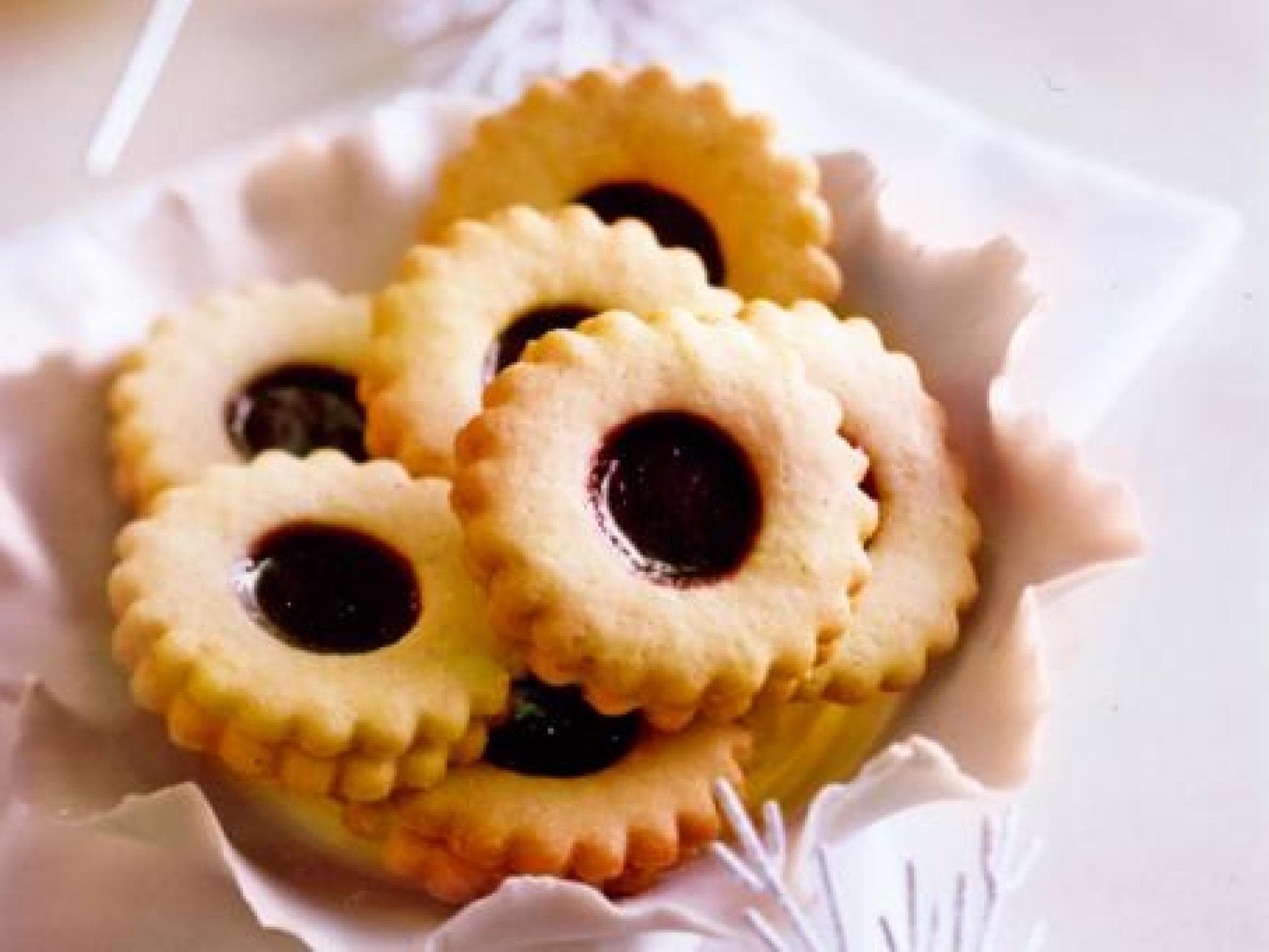 Spitzbuben-Plätzchen mit einer Füllung aus Kirschkonfitüre Spitzbuben-Plätzchen mit einer Füllung aus Kirschkonfitüre