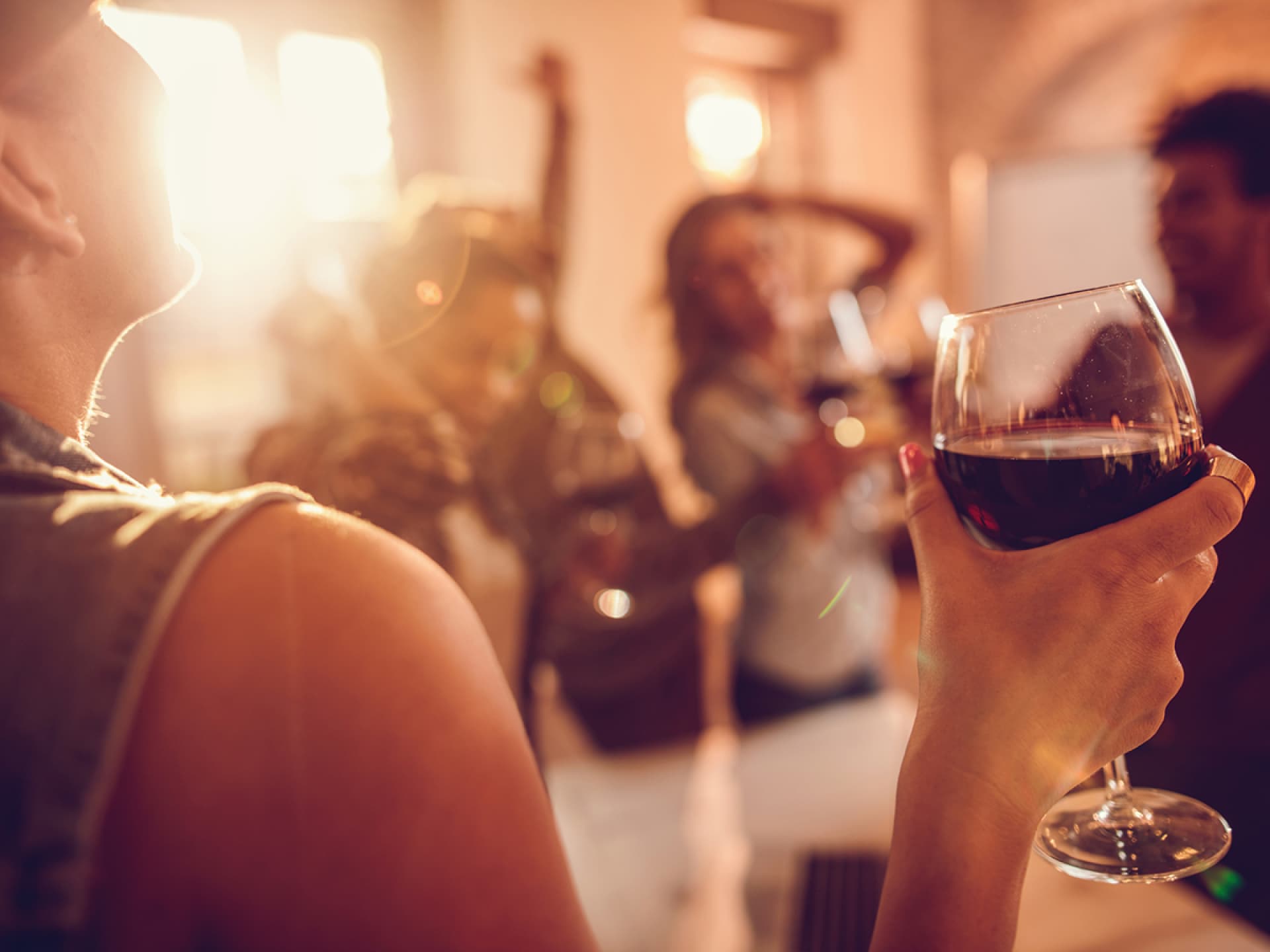 Frau trinkt ein Glas Rotwein Frau trinkt ein Glas Rotwein. Gegen einen Kater helfen diese Tipps.