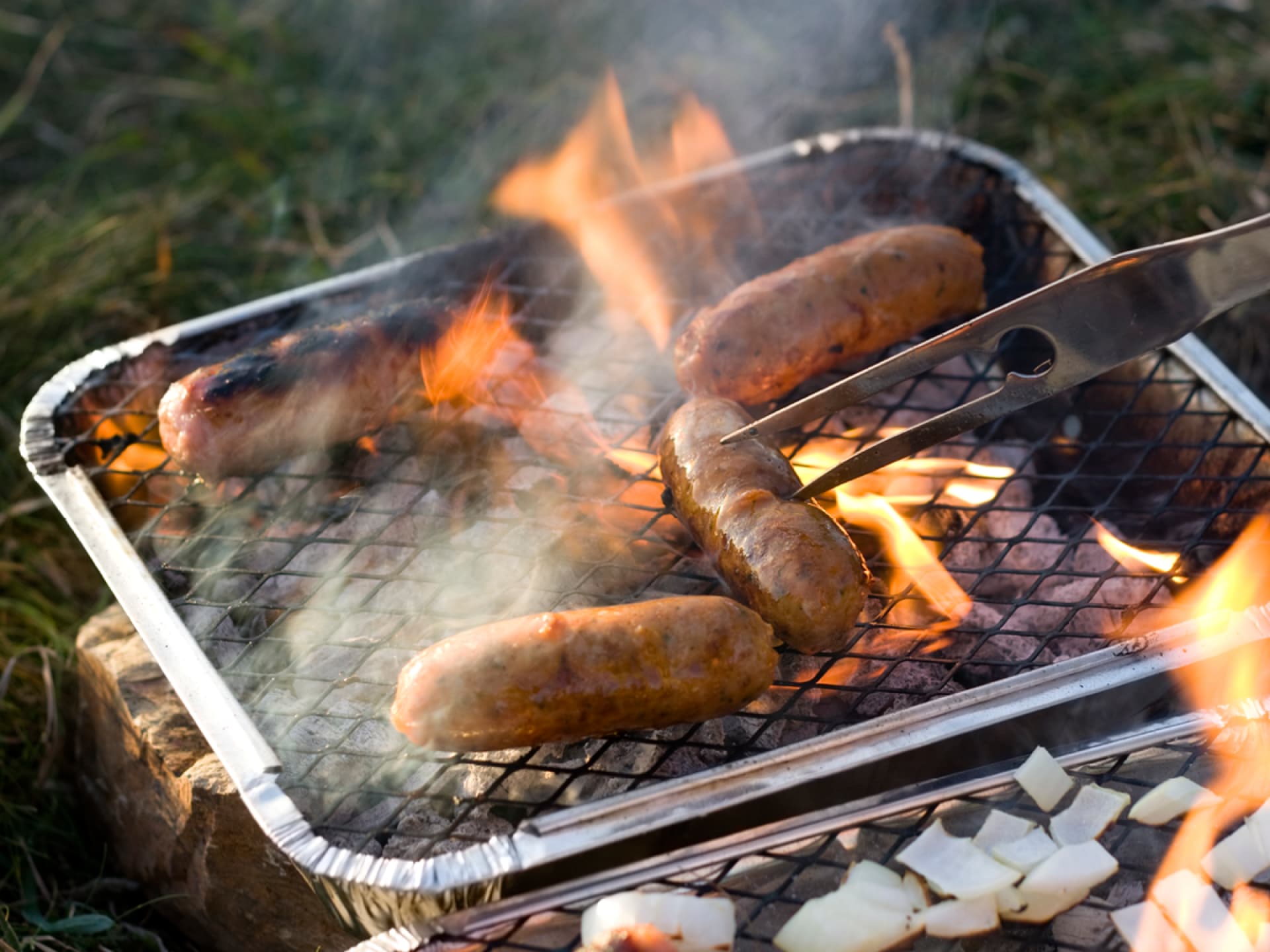 Einweggrills Würstchen auf dem Einweggrill