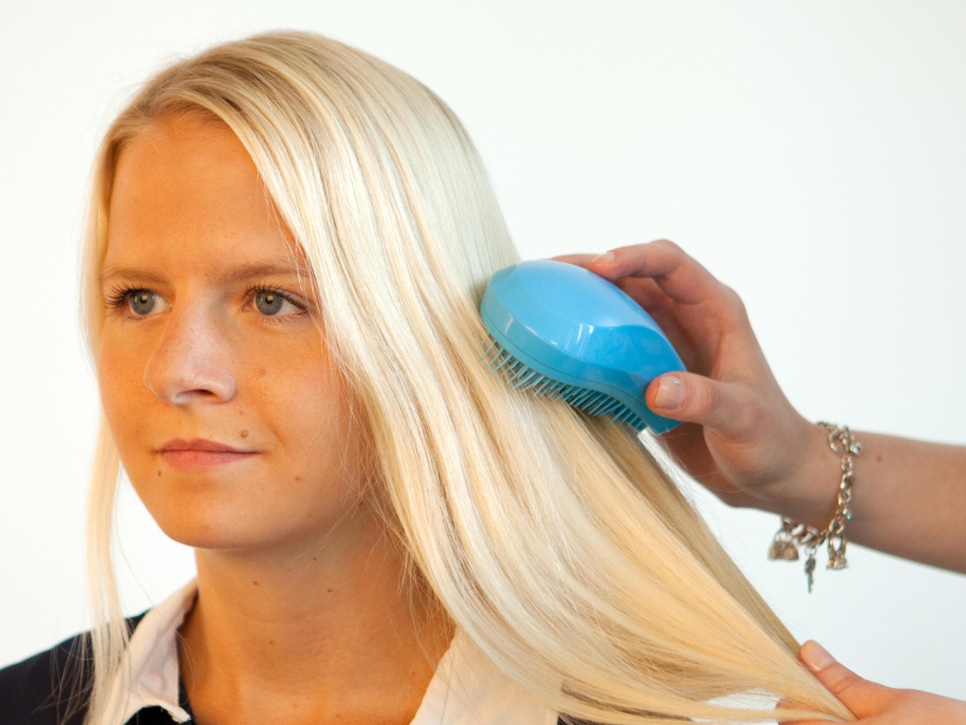 Die Haare einer Frau werden durchgekämmt