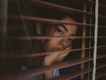 Frau schaut aus Fenster