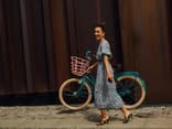 Frau mit langem Kleid und Fahrrad