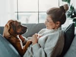 Frau kuschelt mit Hund