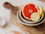 Eine halbe Grapefruit liegt auf einem Schneidebrett.