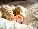 Baby liegt auf dem Bett