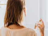 Frau sprüht Parfum wie frische Wäsche