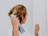 Frau sprüht Haarspray