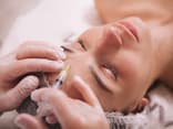 Frau bekommt Botox gegen Migräne in die Stirn gespritzt