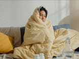 Frau ist komplett in einer Decke eingewickelt
