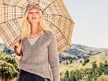 Model in beigefarbenem Sommerpullover mit V-Ausschnitt