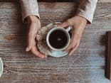 Tasse Kaffee zwischen den Händen