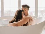 Mann und Frau sitzen umschlungen in der Badewanne