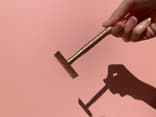 Frau hält Rasierhobel aus Metall