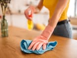 Frau entfernt Staub mit Hausmitteln