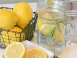 Zitronen und ein Glas mit Wasser und Zitronenscheiben
