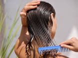 Eine Frau kämmt nasse Haare.